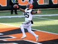 A Cincinnati Bengals football player runs over the finish line with his hands outstretched joyously